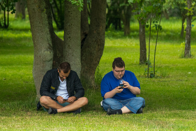 two men playing Pokemon Go in the park
