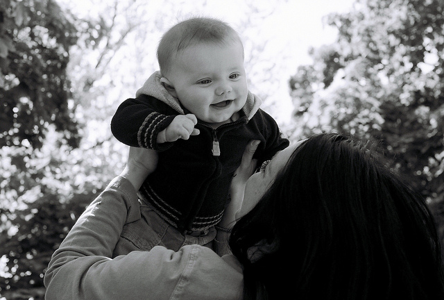 mom holding baby above her shoulders