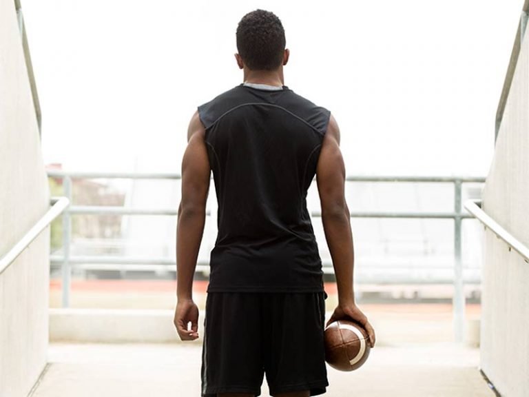 African American football athlete looking into a stadium