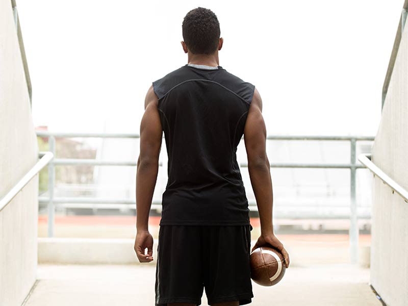 African American football athlete looking into a stadium