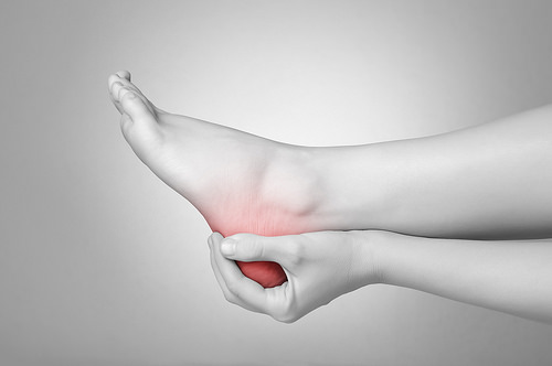 patient holding the bottom of their foot that feels like it's on ice