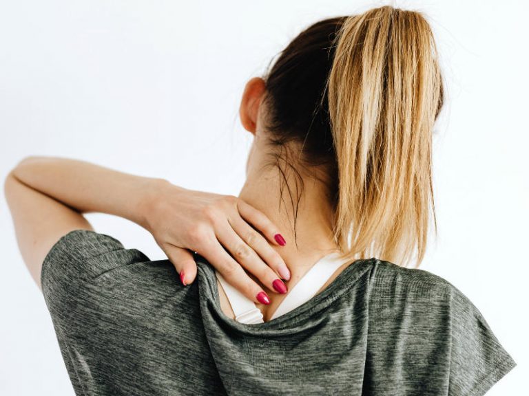 woman reaching for lower back neck