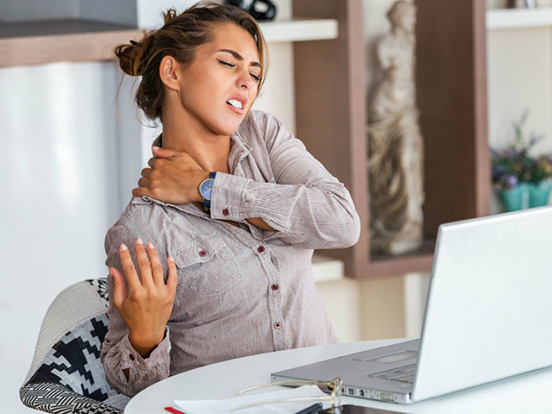 woman with neck & back pain working at home